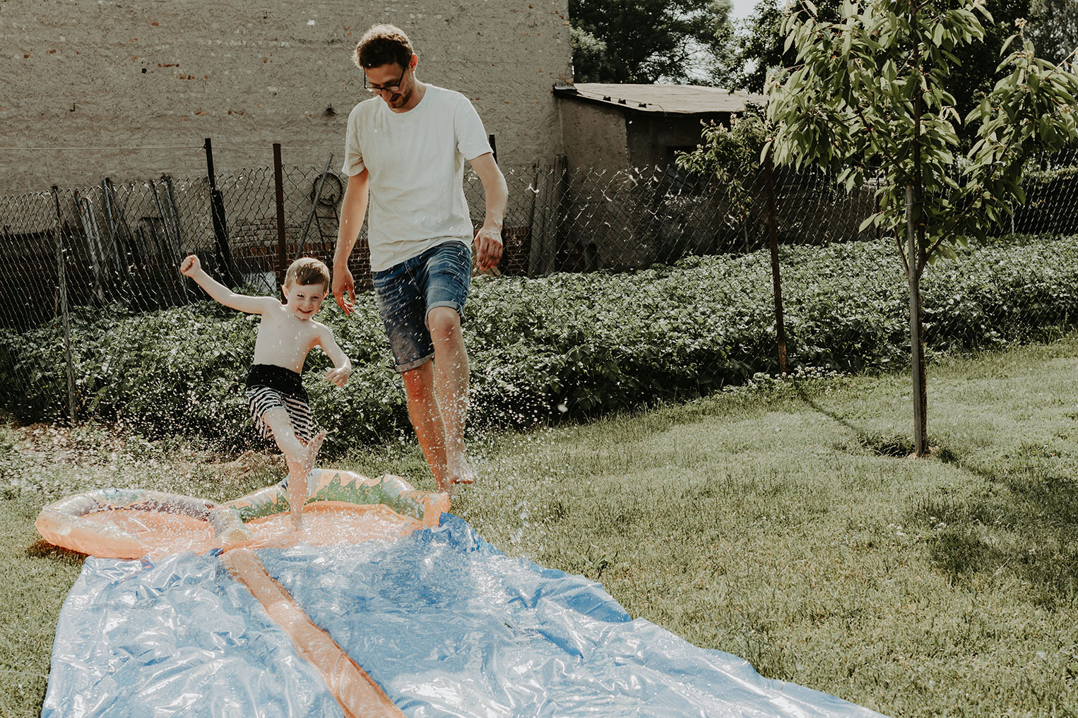 Papa und Kind spielen mit Wasserrutsche